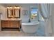 Charming bathroom featuring a wood vanity, soaking tub, and designer tile at 5918 Beaconpark St, Lithia, FL 33547