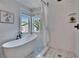 Bright bathroom with white subway tile, soaking tub, and glass-enclosed shower at 5918 Beaconpark St, Lithia, FL 33547