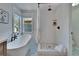 Bright bathroom with white subway tile, soaking tub, and glass-enclosed shower at 5918 Beaconpark St, Lithia, FL 33547