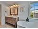 Charming bathroom featuring a wood vanity, soaking tub, and designer tile at 5918 Beaconpark St, Lithia, FL 33547