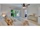 Bedroom featuring a large window, ceiling fan, dresser and a bright bathroom at 5918 Beaconpark St, Lithia, FL 33547