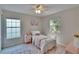 Charming bedroom with two windows, ceiling fan, and floral accents at 5918 Beaconpark St, Lithia, FL 33547