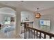 Bright foyer with wood staircase, chandelier, and arched doorways to living areas at 5918 Beaconpark St, Lithia, FL 33547