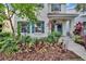 Beautiful two-story home featuring lush tropical landscaping, colorful plants, and blue shutters for added curb appeal at 5918 Beaconpark St, Lithia, FL 33547