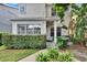 Charming home exterior featuring a well-maintained hedge, lush plants, and a welcoming covered entrance at 5918 Beaconpark St, Lithia, FL 33547