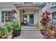 Inviting front porch with a cozy bench, decorative plants, and a wreath on the blue front door at 5918 Beaconpark St, Lithia, FL 33547
