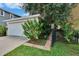 Attached one car garage with white door, landscaping and black metal fence at 5918 Beaconpark St, Lithia, FL 33547
