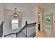 Upstairs hallway featuring a decorative light fixture and access to the bathroom at 5918 Beaconpark St, Lithia, FL 33547