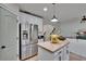 Open-concept living with an island, stainless refrigerator and seamless flow into the adjacent room at 5918 Beaconpark St, Lithia, FL 33547