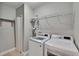 Laundry room with white washer and dryer, wire shelving, and a neutral color scheme at 5918 Beaconpark St, Lithia, FL 33547