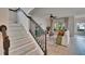Elegant living area with staircase, white couch, area rug, and plenty of light at 5918 Beaconpark St, Lithia, FL 33547