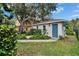 Exterior view of a quaint backyard shed featuring a blue door and surrounded by lush greenery at 5918 Beaconpark St, Lithia, FL 33547