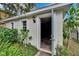 Rear view of a small shed with a blue door, adjacent to a fenced yard and verdant landscaping at 5918 Beaconpark St, Lithia, FL 33547