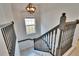 Staircase with dark railing and globe light fixture at 5918 Beaconpark St, Lithia, FL 33547