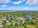 Aerial view showcasing a charming neighborhood with homes nestled among mature trees and a serene lake at 602 Timber Bay W Cir, Oldsmar, FL 34677
