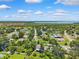 Wide aerial shot of a residential area, highlighting tree-lined streets and homes with lush yards, with a large lake nearby at 602 Timber Bay W Cir, Oldsmar, FL 34677