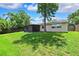 Well-maintained backyard with a screen porch and ample lawn space surrounded by mature trees for privacy at 602 Timber Bay W Cir, Oldsmar, FL 34677