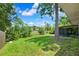 Expansive backyard with lush green lawn, mature trees, and a screened lanai area perfect for outdoor enjoyment at 602 Timber Bay W Cir, Oldsmar, FL 34677