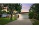 Charming one-story home with a well-maintained lawn and inviting curb appeal at dusk at 602 Timber Bay W Cir, Oldsmar, FL 34677