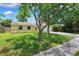 Charming single-story home with a well-manicured front yard, mature trees, and a two-car garage at 602 Timber Bay W Cir, Oldsmar, FL 34677