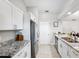 Well-lit kitchen featuring granite countertops, stainless steel appliances, and white cabinetry at 602 Timber Bay W Cir, Oldsmar, FL 34677