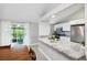 Open kitchen with granite countertops, stainless steel appliances, and view of the screened porch at 602 Timber Bay W Cir, Oldsmar, FL 34677