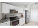 This kitchen features stainless steel appliances, granite countertops, and white cabinets at 602 Timber Bay W Cir, Oldsmar, FL 34677