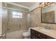 Bathroom featuring modern vanity, tiled walls, glass shower door and modern vanity lighting at 6658 Stewart N Ave, St Petersburg, FL 33702