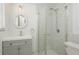 Modern bathroom featuring a glass shower, sleek vanity, and decorative round mirror at 6658 Stewart N Ave, St Petersburg, FL 33702