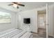 Bright bedroom features a ceiling fan, a TV, and a patterned bedspread at 6658 Stewart N Ave, St Petersburg, FL 33702