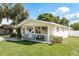Inviting single-story home with manicured lawn and comfortable seating on the front porch at 6658 Stewart N Ave, St Petersburg, FL 33702