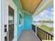 Outdoor balcony view of a bay with blue siding, dark railings and wood ceiling at 6679 Wander Ln, New Port Richey, FL 34652