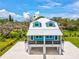 Charming coastal-style home with a metal roof, eye-catching blue accents and a raised design with covered parking at 6679 Wander Ln, New Port Richey, FL 34652