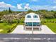 Beautiful home with eye-catching blue accents, a metal roof, and an elevated design situated on a well-maintained lawn at 6679 Wander Ln, New Port Richey, FL 34652