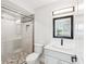 Bright bathroom with tile shower, stone mosaic floor, and gray vanity with black fixtures at 6707 Wander Ln, New Port Richey, FL 34654