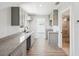 Charming kitchen featuring sleek gray cabinets, granite counters, and wood-look laminate flooring at 6707 Wander Ln, New Port Richey, FL 34654
