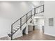 Modern living space featuring sleek railing staircase, laminate flooring, and a convenient wet bar at 6707 Wander Ln, New Port Richey, FL 34654
