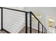 Modern black metal and cable staircase with wood treads and luxury vinyl flooring at 6707 Wander Ln, New Port Richey, FL 34654