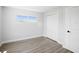 Bright bedroom features a window, closet, wood-look flooring and fresh paint at 6715 Wander Ln, New Port Richey, FL 34654