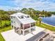 Beautiful coastal home featuring a metal roof, elevated design, and charming porch overlooking the serene waterfront at 6715 Wander Ln, New Port Richey, FL 34654