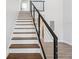 Staircase with wood stairs, steel cable railing, and hardwood floors at 6715 Wander Ln, New Port Richey, FL 34654