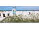 Serene beach scene with lifeguard stand, beachgoers, and natural dune vegetation at 6800 Sunset Way # 1708, St Pete Beach, FL 33706