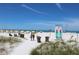 Beautiful day at the beach with beachgoers, colorful umbrellas, and clear blue skies at 6800 Sunset Way # 1708, St Pete Beach, FL 33706
