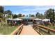 Attractive outdoor cafe area with boardwalk entrance, patio umbrellas, and surrounding palm trees at 6800 Sunset Way # 1708, St Pete Beach, FL 33706