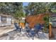 Charming backyard with a modern fire pit surrounded by Adirondack chairs, perfect for outdoor gatherings at 6806 N 17Th St, Tampa, FL 33610