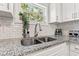 Close-up on a granite countertop and stainless steel sink in a bright, updated kitchen at 6806 N 17Th St, Tampa, FL 33610