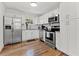 Bright kitchen featuring white cabinets, stainless steel appliances, and hardwood floors at 6806 N 17Th St, Tampa, FL 33610