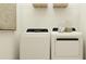 Bright laundry room with modern white washer and dryer, and ample shelving at 6830 E 115Th St, Palmetto, FL 34221