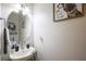 This bathroom has a white sink, round mirror, grey hand towel and framed cartoon dog art at 6925 Marble Fawn Pl, Riverview, FL 33578