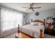 This bedroom has a queen-sized bed, wood furniture, a ceiling fan and sheer curtains at 6925 Marble Fawn Pl, Riverview, FL 33578